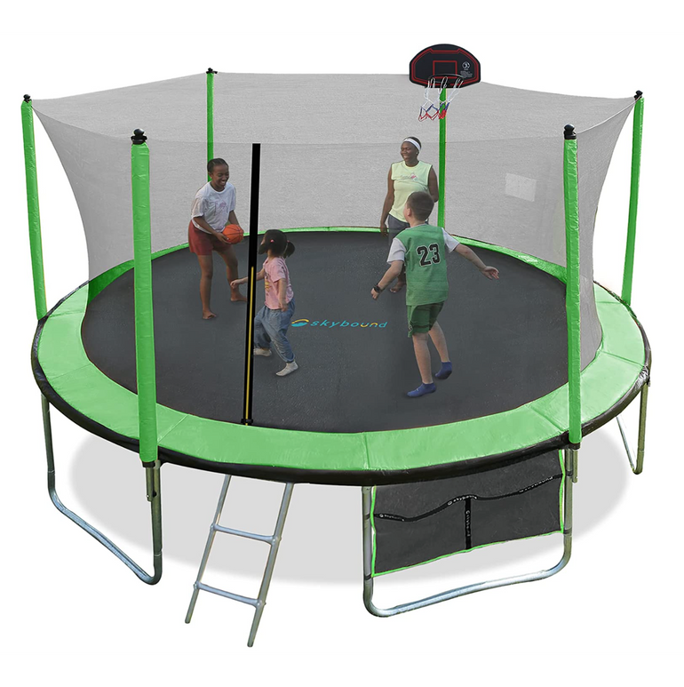 An adult and three children playing basketball on a trampoline