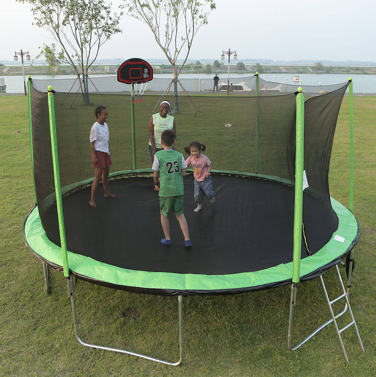 4 people playing basketball on the skybound green 16ft trampoline