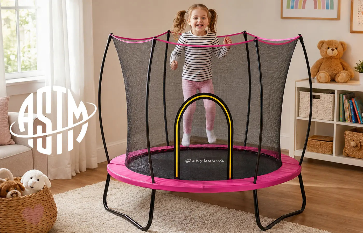 ASTM Certified banner for SkyBound pink children trampoline, little girl jumping indoors, ASTM official logo, text showing trampoline complies with ASTM F963, F381, F2225, AS4989 standards, tested for heavy metals, lead and flammability for kid-safe play