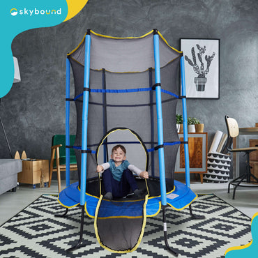 There is a blue 55 inch mini trampoline in the living room at home_and a boy is sitting on it